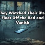 A tablet device hovering a few inches above a bed in a dark bedroom, beginning to dissolve into glitching digital light and shadow, the room flickering with eerie blue light.