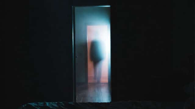 terrifying ghost in the doorway of a home.